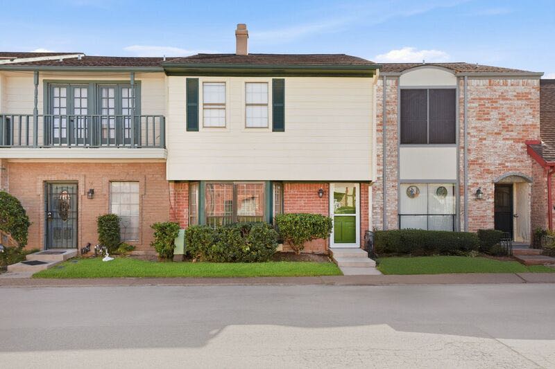 A row of attached Houston residences with brick, siding, and planted entries
